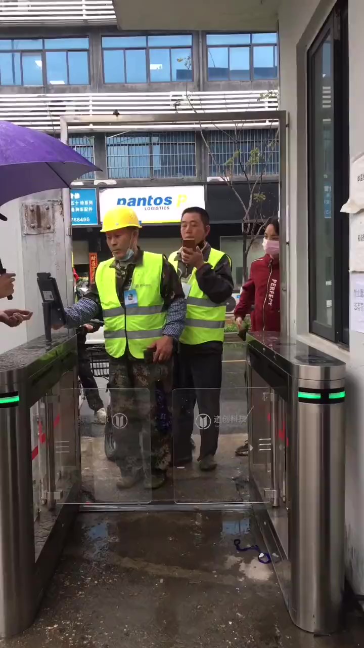 工人在闸机式电子哨兵前扫码进场 工人在闸机式电子哨兵前扫码进场